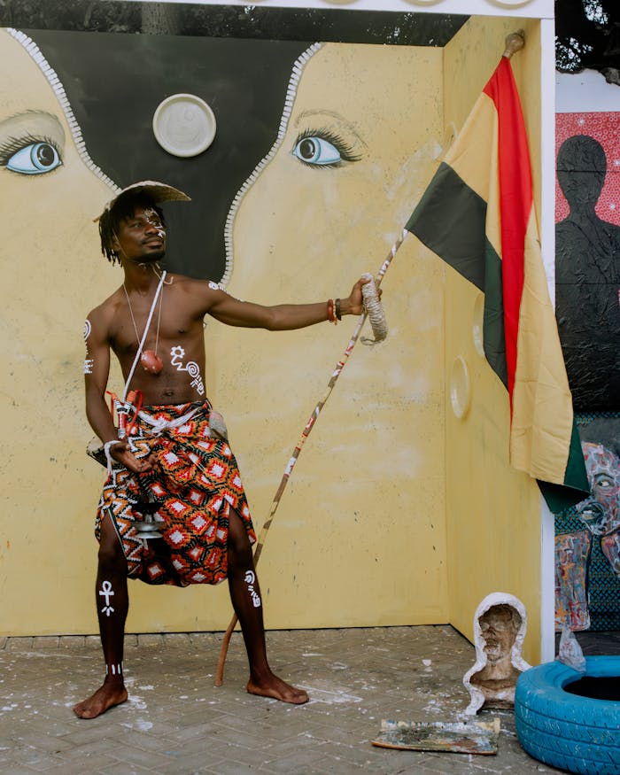 Vibrant depiction of African cultural expression with traditional attire and striking mural backdrop.
